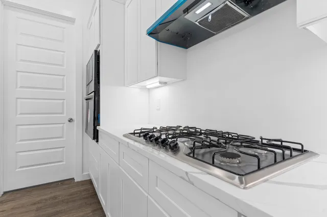 a kitchen with kitchen island a counter top space a sink and cabinets