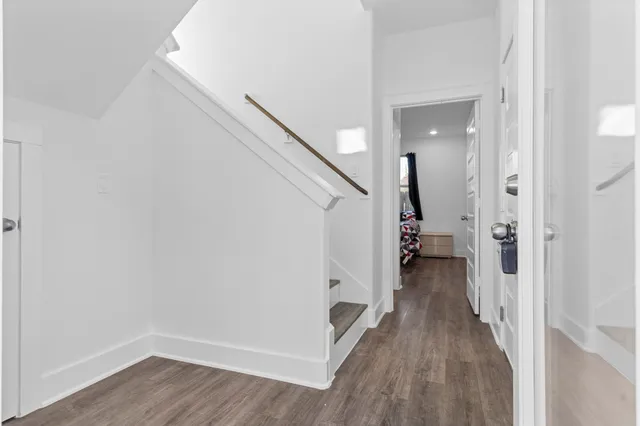 a kitchen with stainless steel appliances granite countertop a stove a sink a refrigerator and a dining table with wooden floor