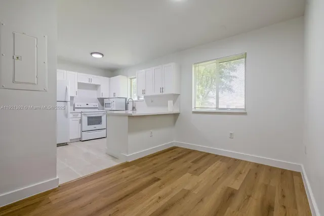 a kitchen with a refrigerator a stove top oven and cabinets
