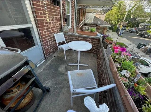 a balcony with chairs and a potted plant