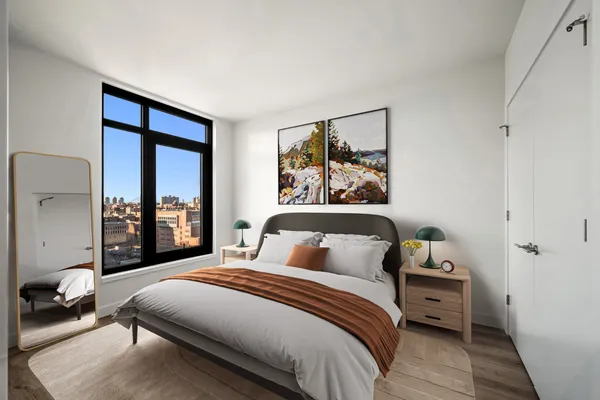 a bedroom with a bed and a large window