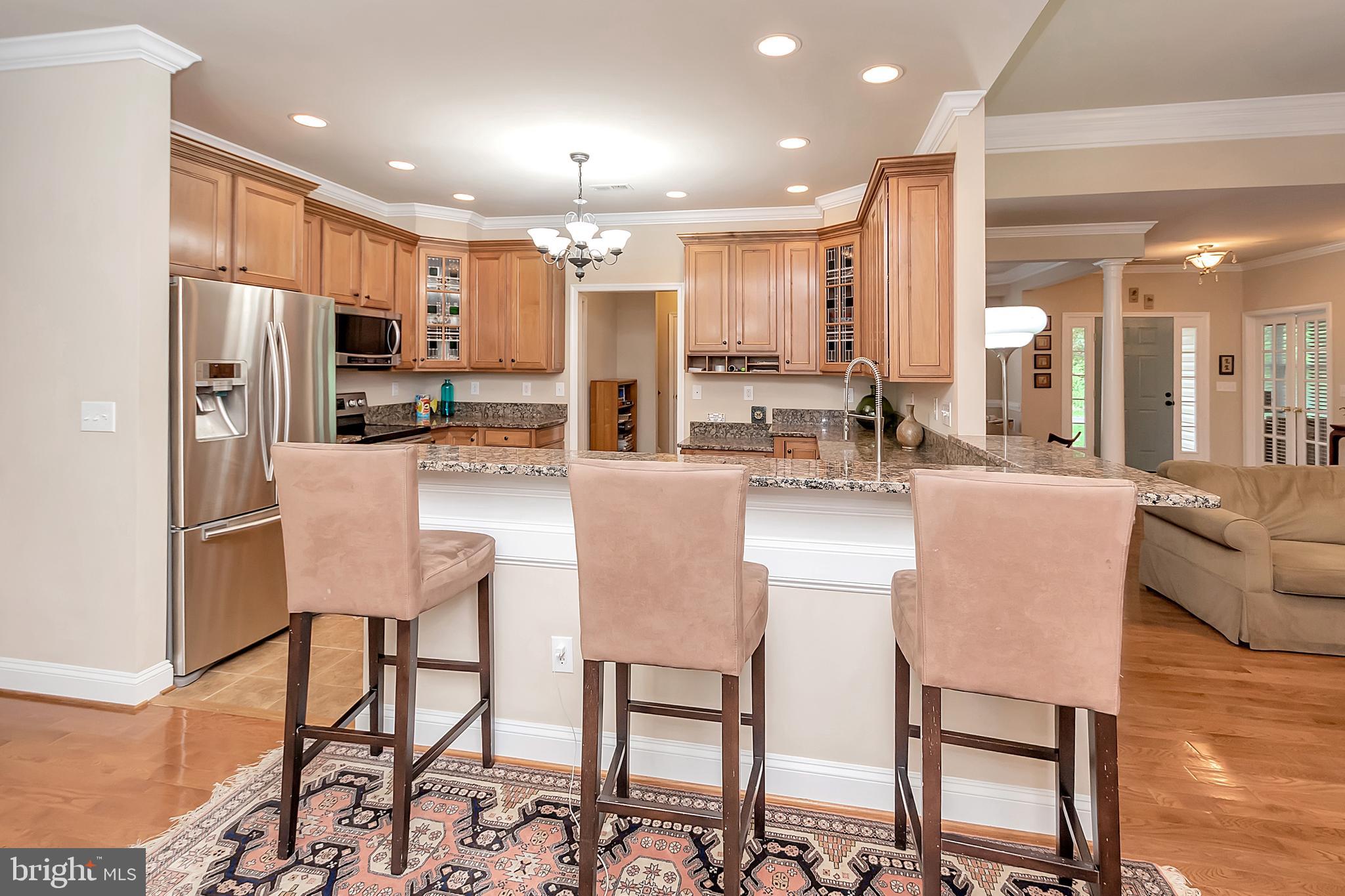 102 Birdie Road Locust Grove, VA 22508 - Photo 12 of 35 a kitchen with stainless steel appliances kitchen island granite countertop a table chairs refrigerator and sink