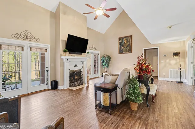 a kitchen with stainless steel appliances granite countertop stove top oven a refrigerator a dining table and chairs with wooden floor