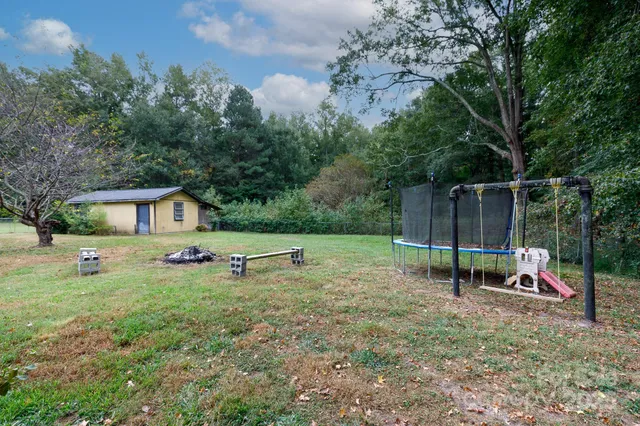 a view of backyard with a slide and a bench