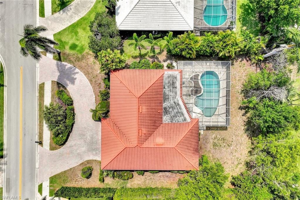 529 Neapolitan Way Naples, FL 34103 - Photo 3 of 18 an aerial view of a house with garden space and a bench