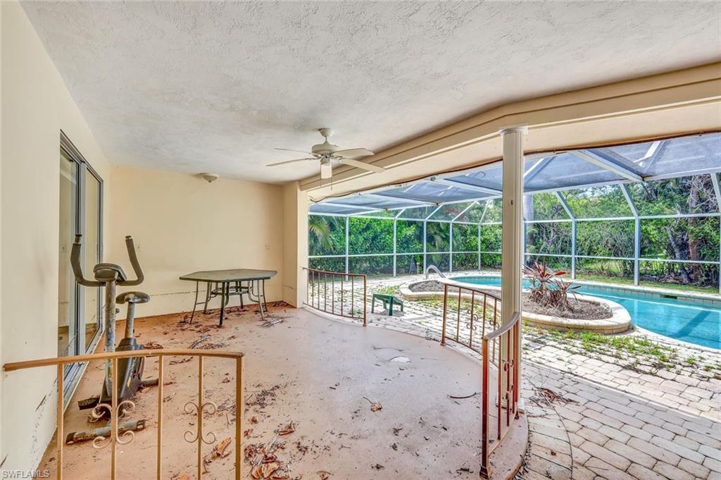 529 Neapolitan Way Naples, FL 34103 - Photo 9 of 18 a living room filled with furniture and large windows