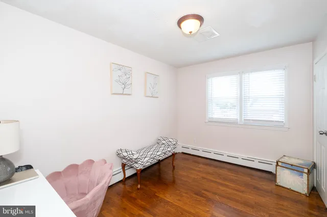 a view of a room with wooden floor and fan