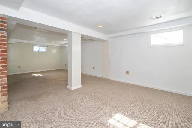 an empty room with entrance and windows