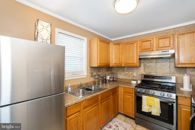 a kitchen with stainless steel appliances a refrigerator sink and cabinets