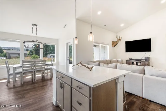 a kitchen with a sink microwave and wooden floor