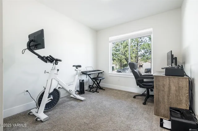 a view of a workspace with furniture and a window