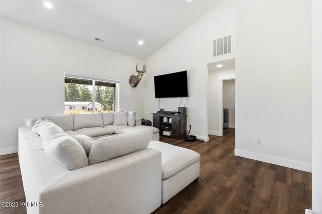 a living room with furniture a flat screen tv and a window