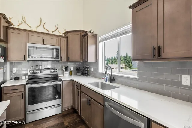 a kitchen with stainless steel appliances a sink a stove and cabinets