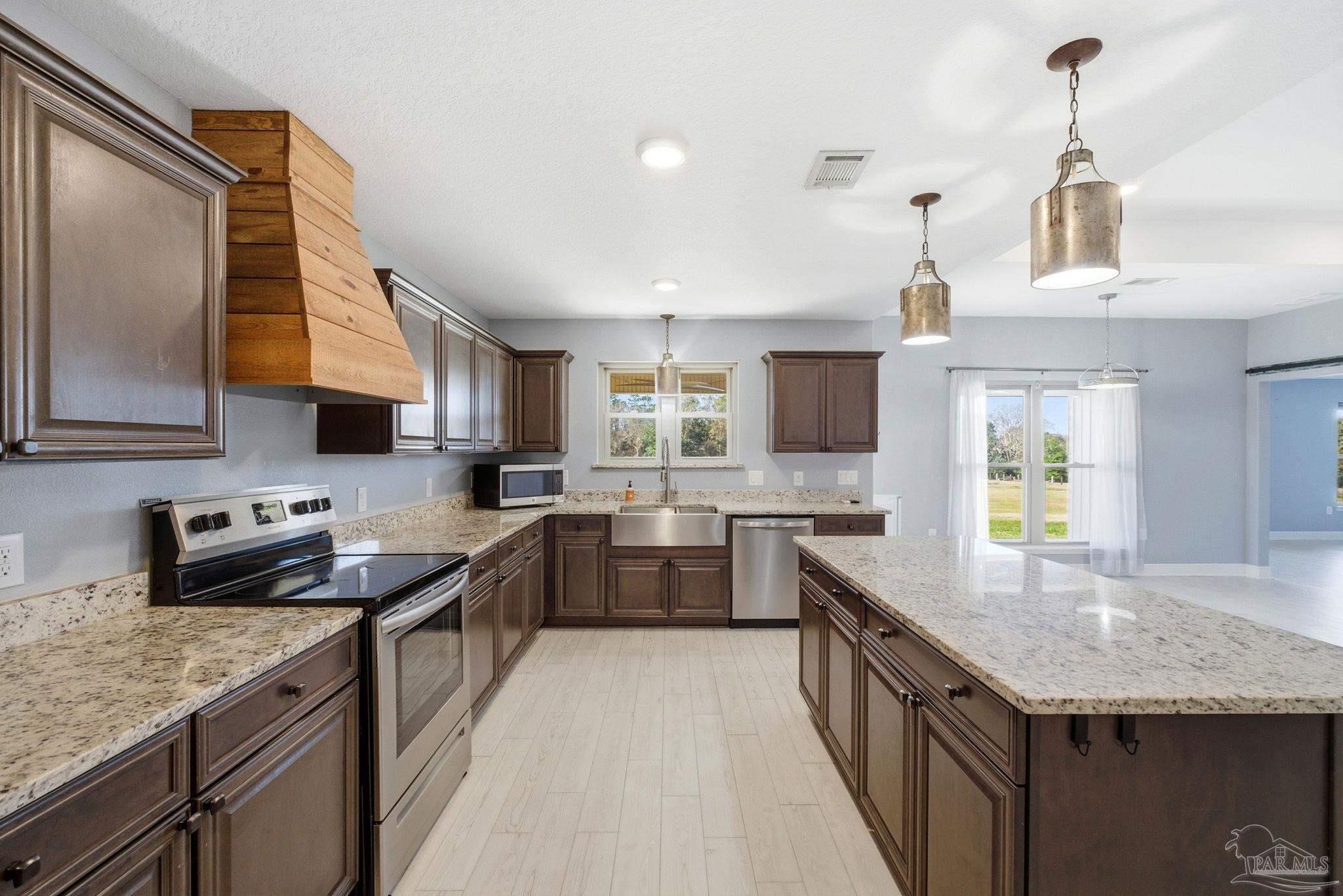 2033 Chavers Road Cantonment, FL 32533 - Photo 11 of 42 a kitchen with stainless steel appliances granite countertop sink stove and refrigerator