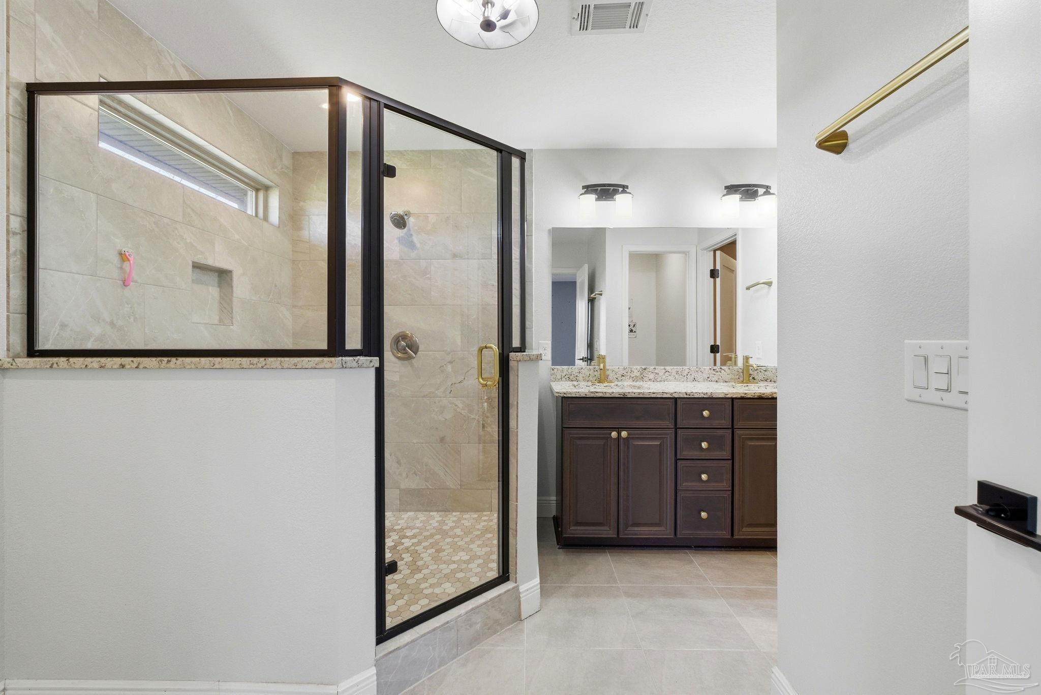 2033 Chavers Road Cantonment, FL 32533 - Photo 17 of 42 a bathroom with a granite countertop sink mirror and a shower