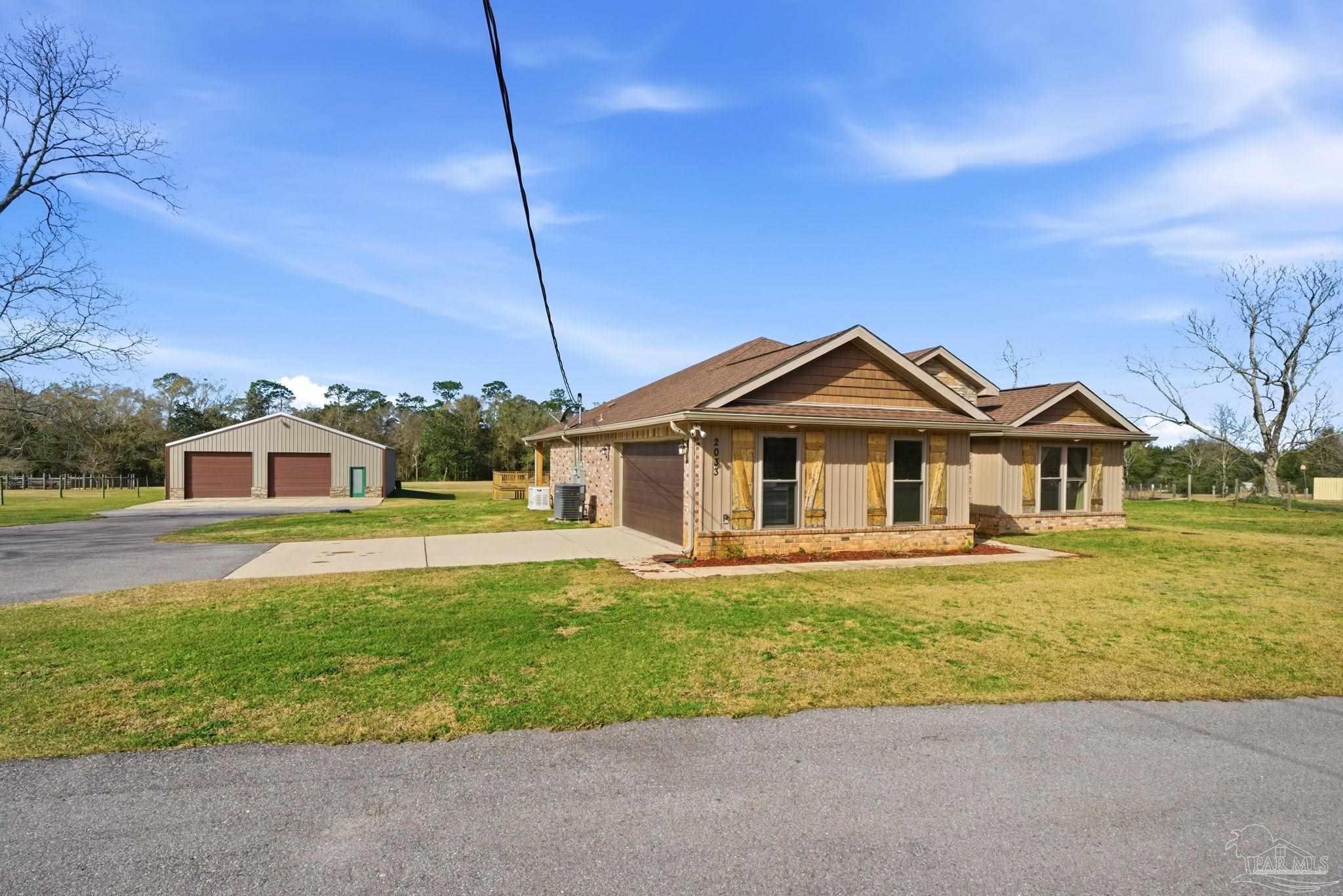 2033 Chavers Road Cantonment, FL 32533 - Photo 2 of 42 a front view of a house with a yard and garage