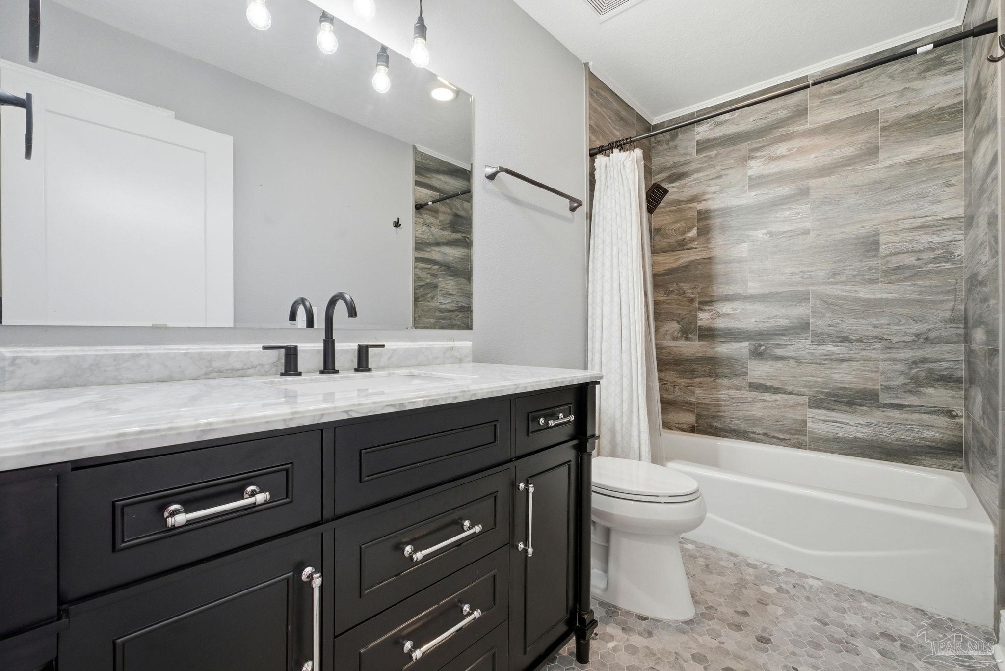 2033 Chavers Road Cantonment, FL 32533 - Photo 22 of 42 a bathroom with a granite countertop sink a toilet a mirror and shower
