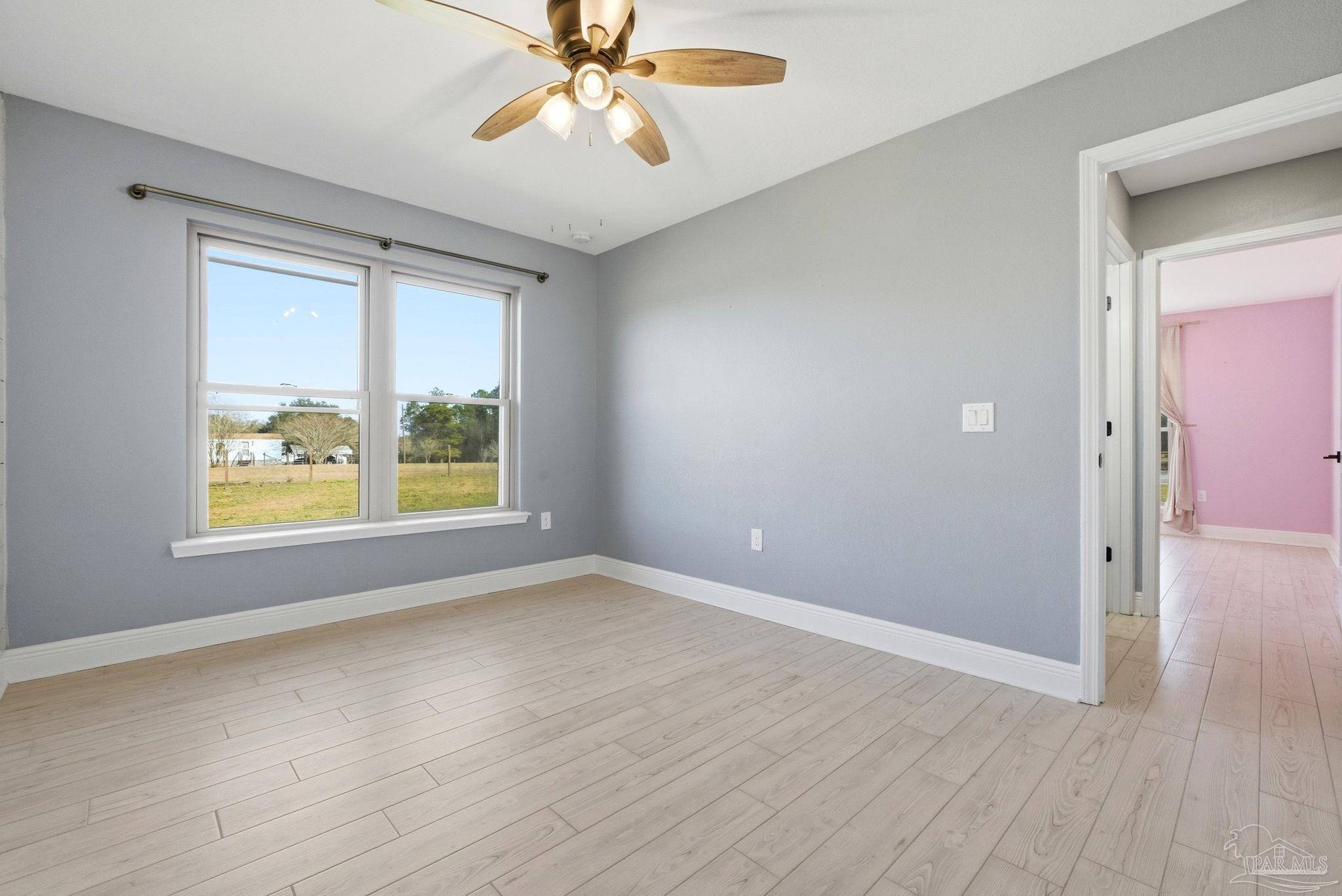 2033 Chavers Road Cantonment, FL 32533 - Photo 23 of 42 a view of an empty room with a window and wooden floor