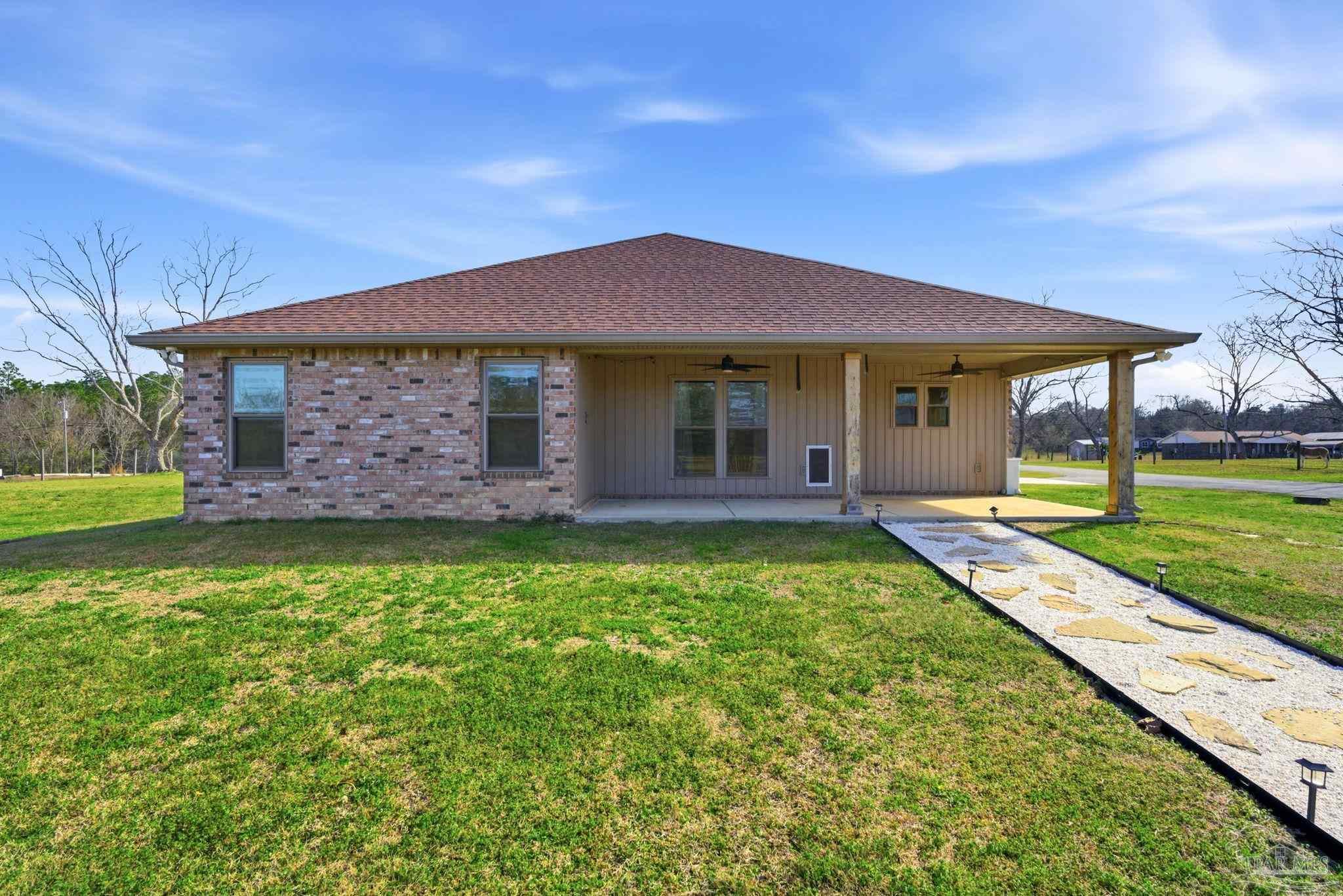 2033 Chavers Road Cantonment, FL 32533 - Photo 30 of 42 a front view of a house with a garden