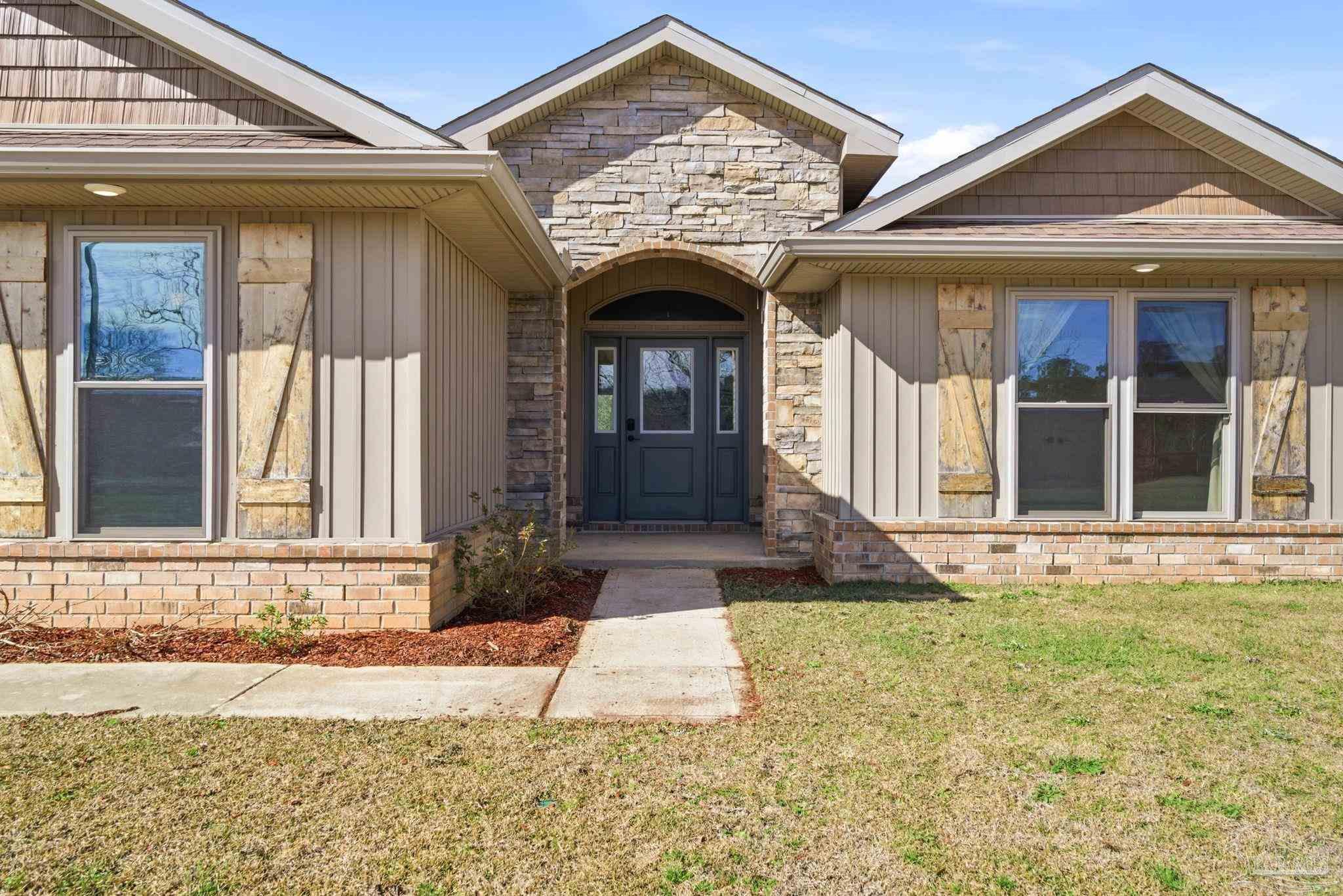 2033 Chavers Road Cantonment, FL 32533 - Photo 3 of 42 a view of a brick house with many windows