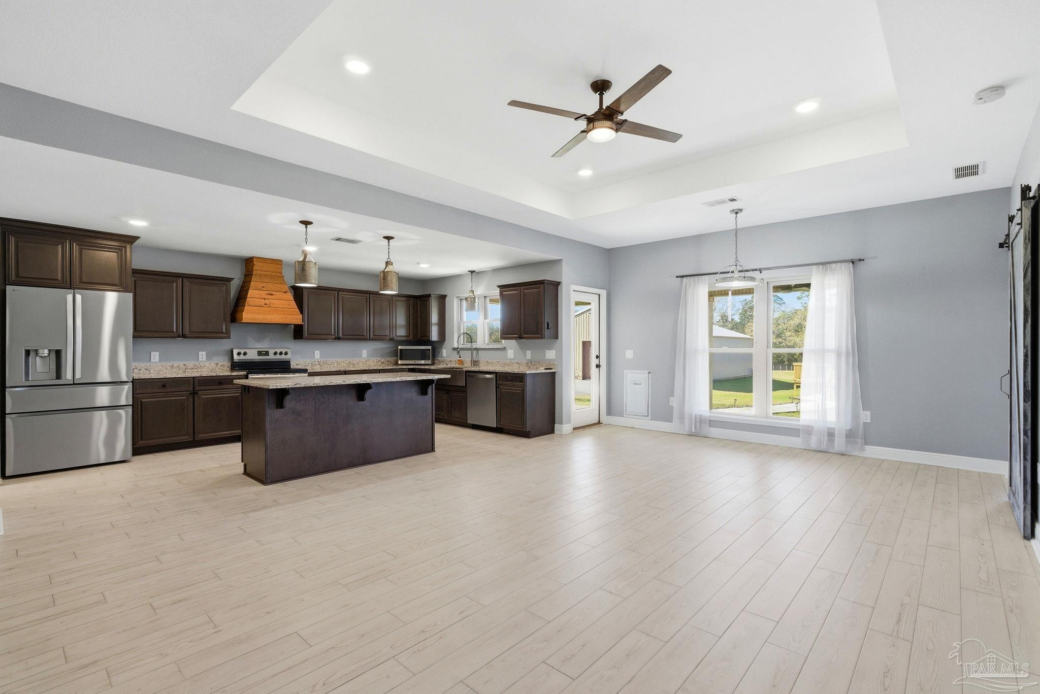 2033 Chavers Road Cantonment, FL 32533 - Photo 6 of 42 a large kitchen with stainless steel appliances kitchen island a large counter top and a wooden floor