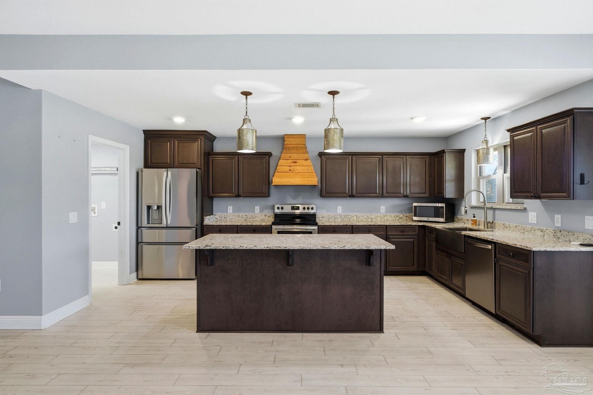 2033 Chavers Road Cantonment, FL 32533 - Photo 7 of 42 a kitchen with stainless steel appliances granite countertop a stove top oven a sink dishwasher and a refrigerator