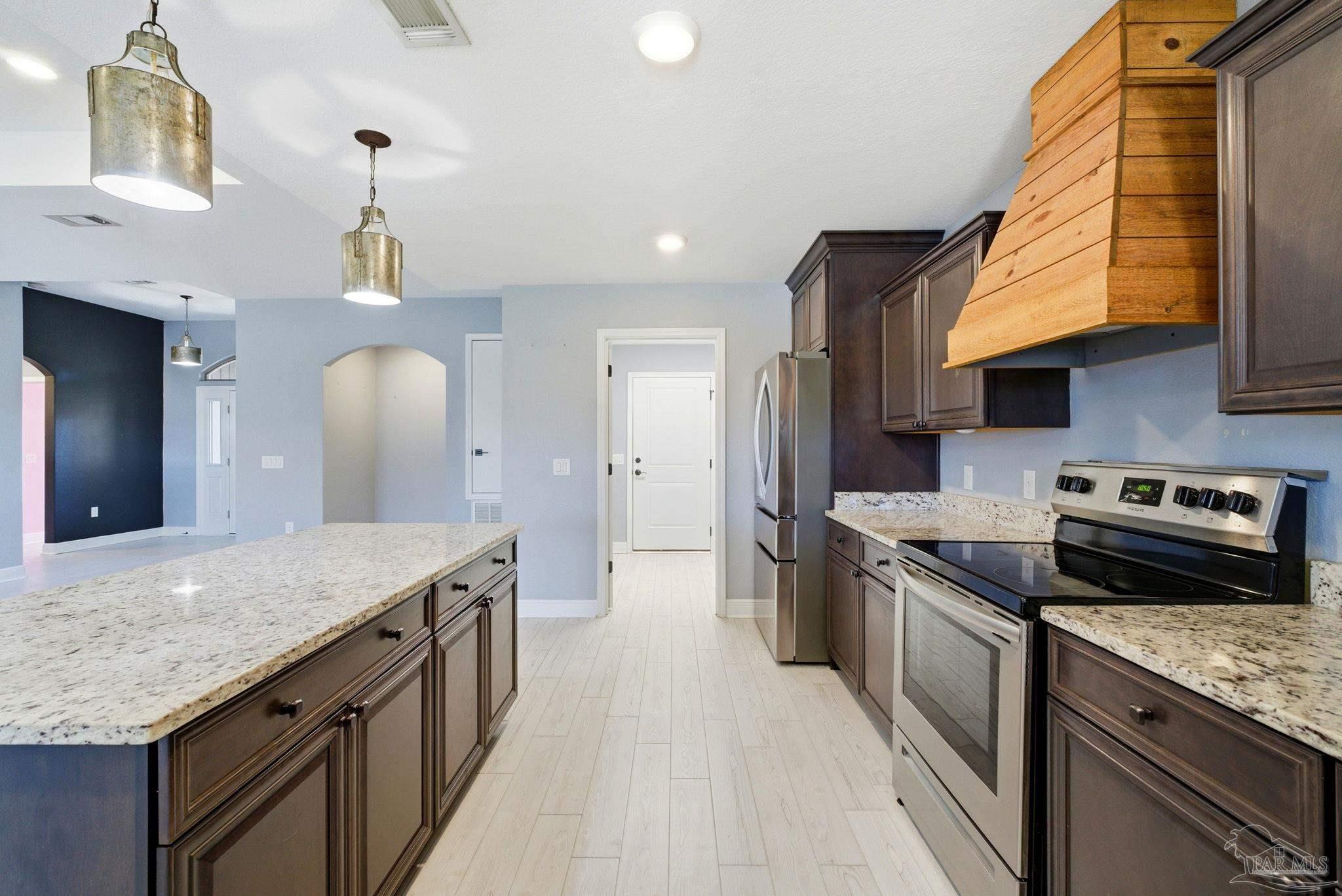 2033 Chavers Road Cantonment, FL 32533 - Photo 9 of 42 a kitchen with stainless steel appliances granite countertop a kitchen island a stove and a sink