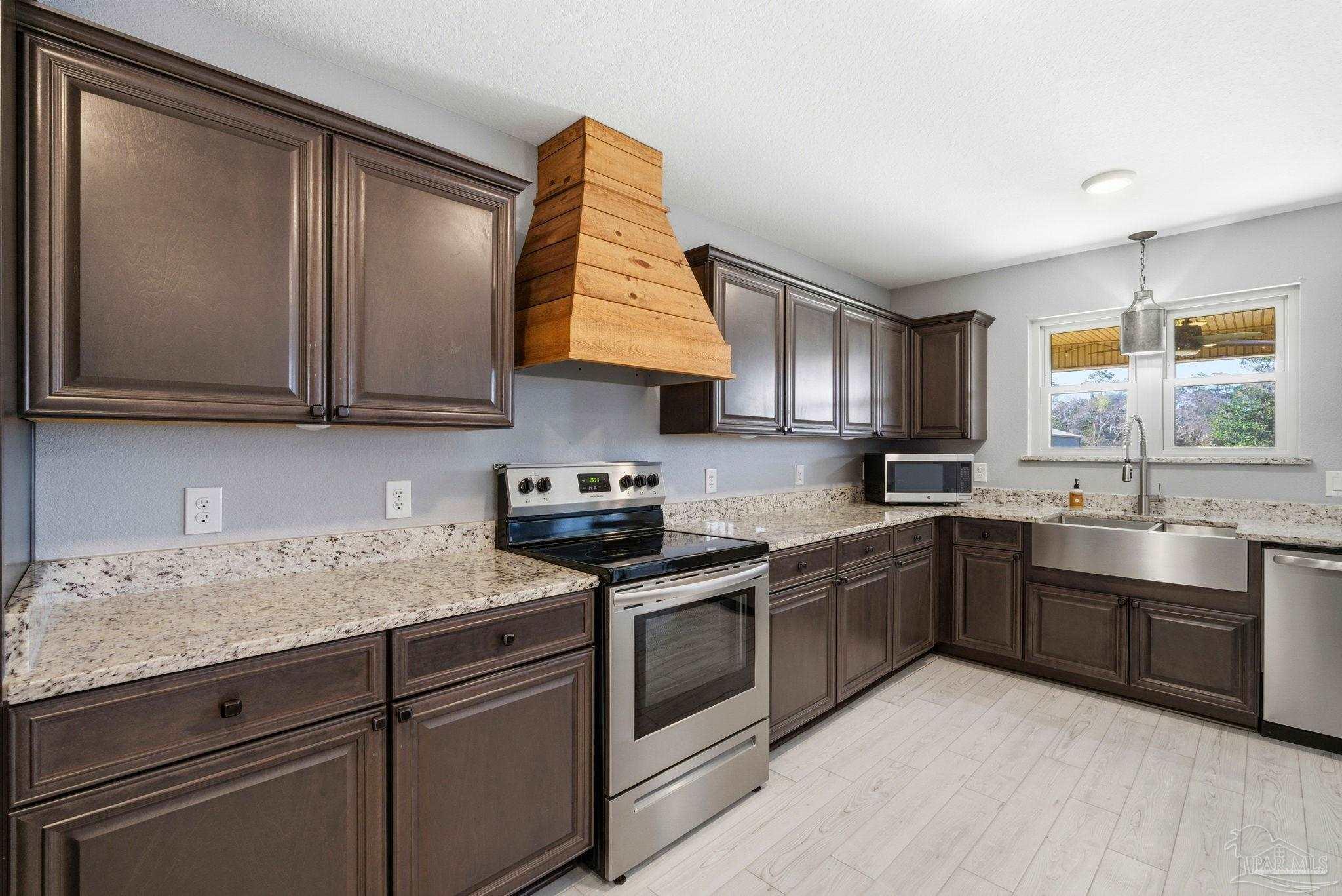 2033 Chavers Road Cantonment, FL 32533 - Photo 10 of 42 a kitchen with granite countertop a sink stainless steel appliances and cabinets