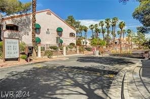 7570 West Flamingo Road, Unit 125 Las Vegas, NV 89147 - Photo 12 of 29 View of asphalt road featuring curbs and a gated entry
