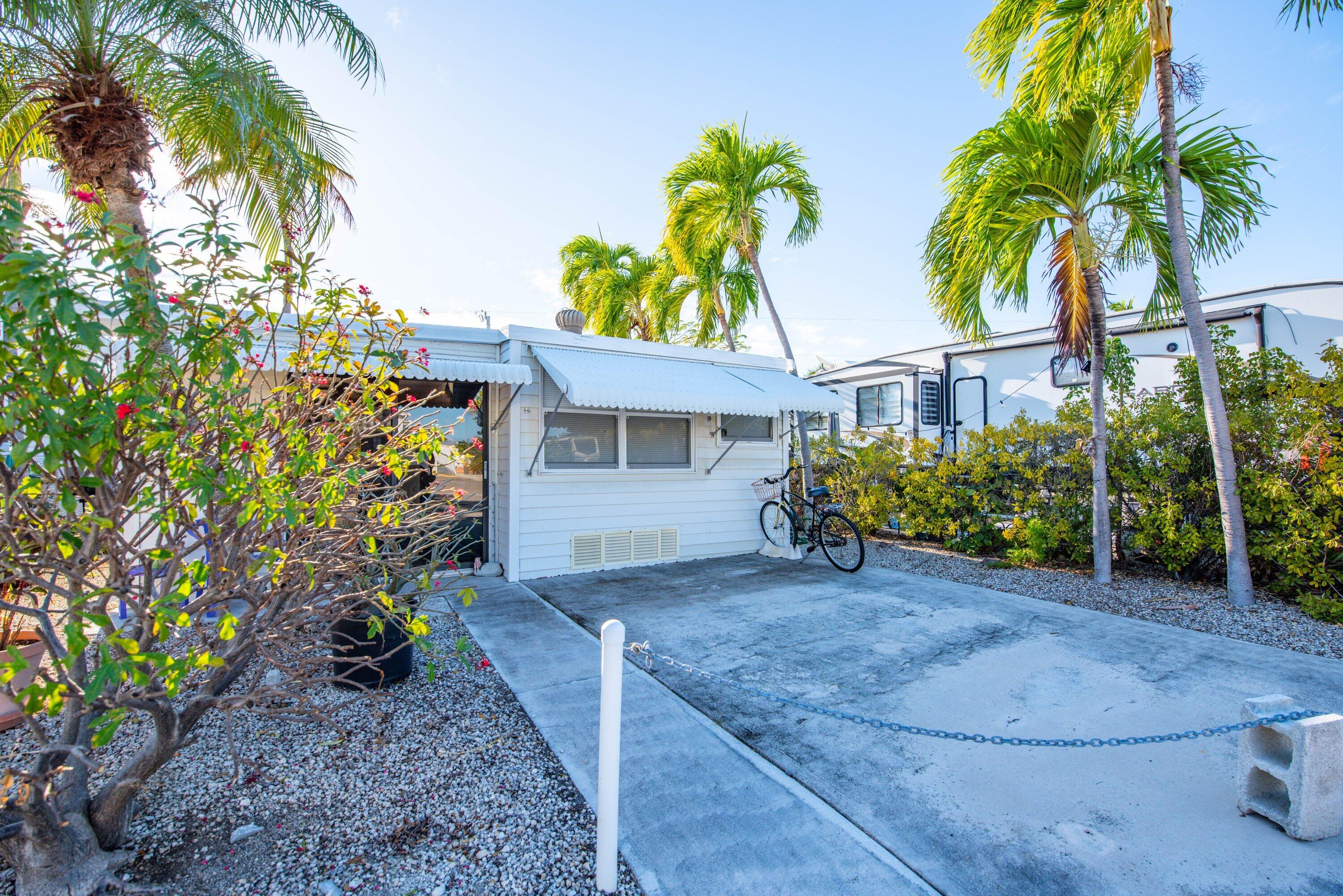 701 Spanish Main Drive, Unit 21 Cudjoe, FL 33042 - Photo 28 of 49 a view of a house with a small yard and palm trees