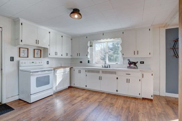 56 Old Belchertown Road Ware, MA 01082 - Photo 3 of 25 a kitchen with granite countertop white cabinets white appliances and wooden floor