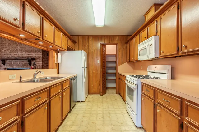 a kitchen with stainless steel appliances granite countertop a stove a sink dishwasher and a refrigerator