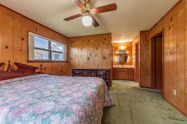 a spacious bedroom with a balcony a bed and a chandelier