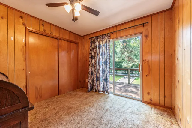 a view of empty room with floor to ceiling window and ceiling fan