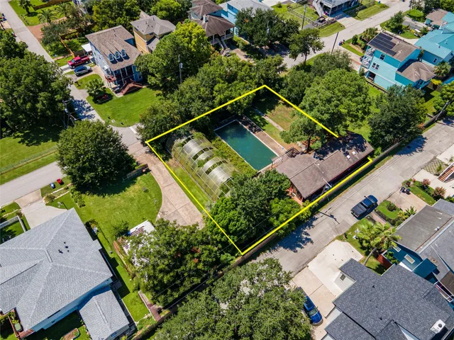 an aerial view of a tennis ground and a houses