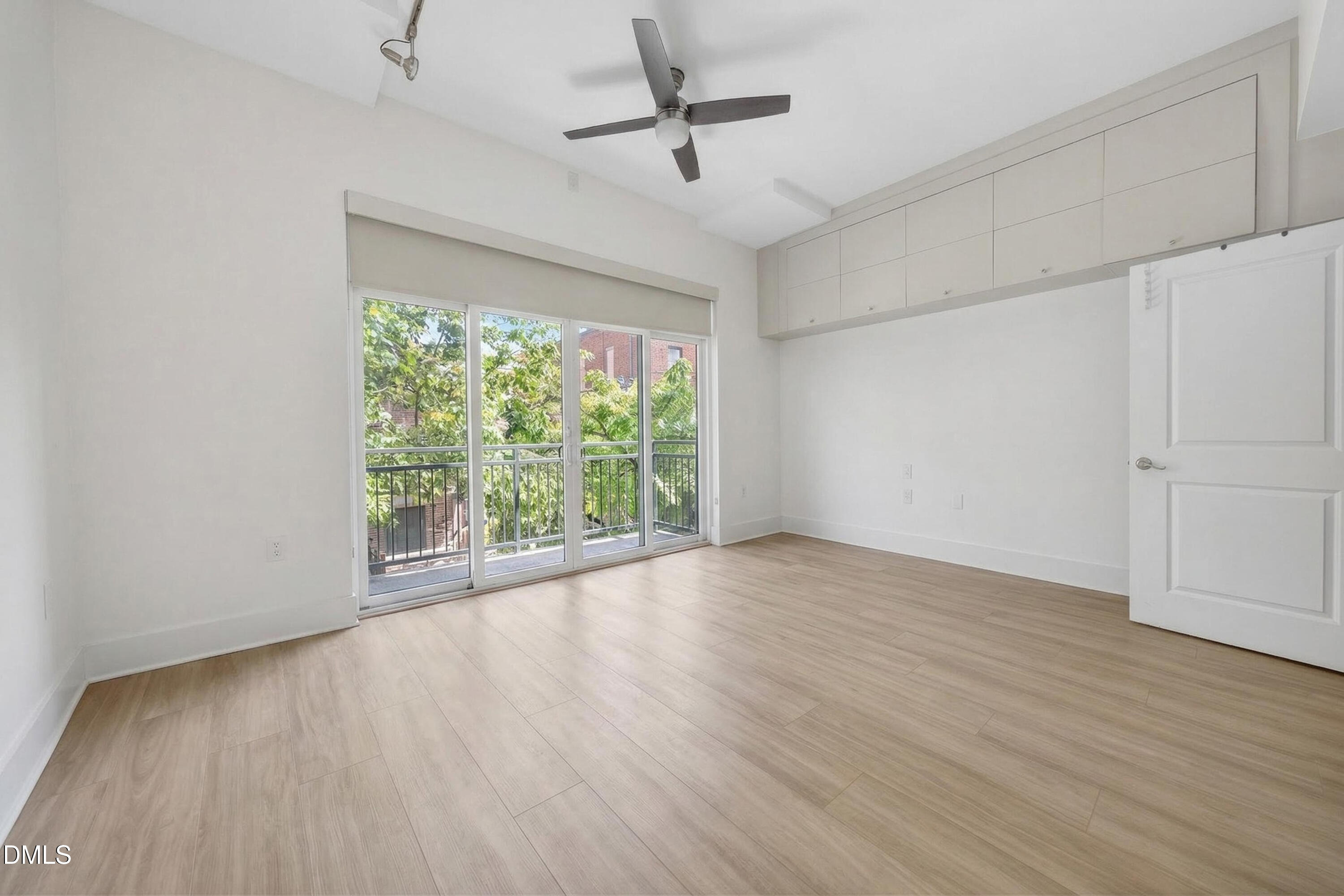 444 South Blount Street, Unit 111 Raleigh, NC 27601 - Photo 14 of 40 an empty room with wooden floor fan and windows