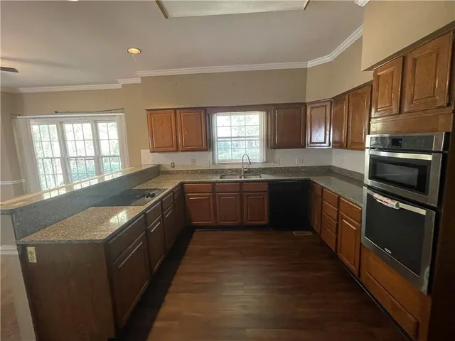 a large kitchen with granite countertop lots of white stainless steel appliances