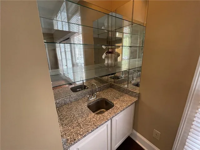 a bathroom with a granite countertop sink and washing machine