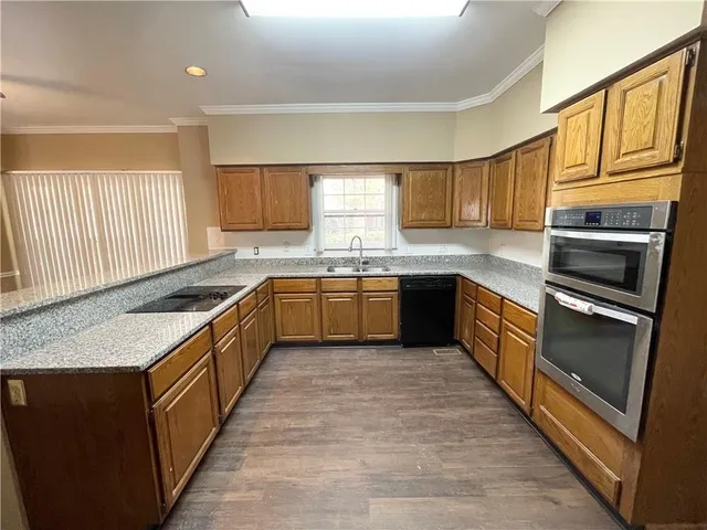 a kitchen with stainless steel appliances granite countertop a stove a sink dishwasher and a refrigerator
