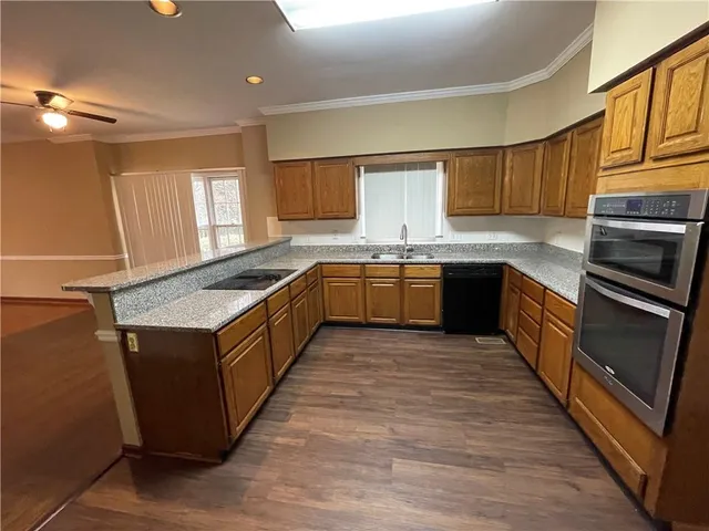 a kitchen with wooden cabinets sink and microwave