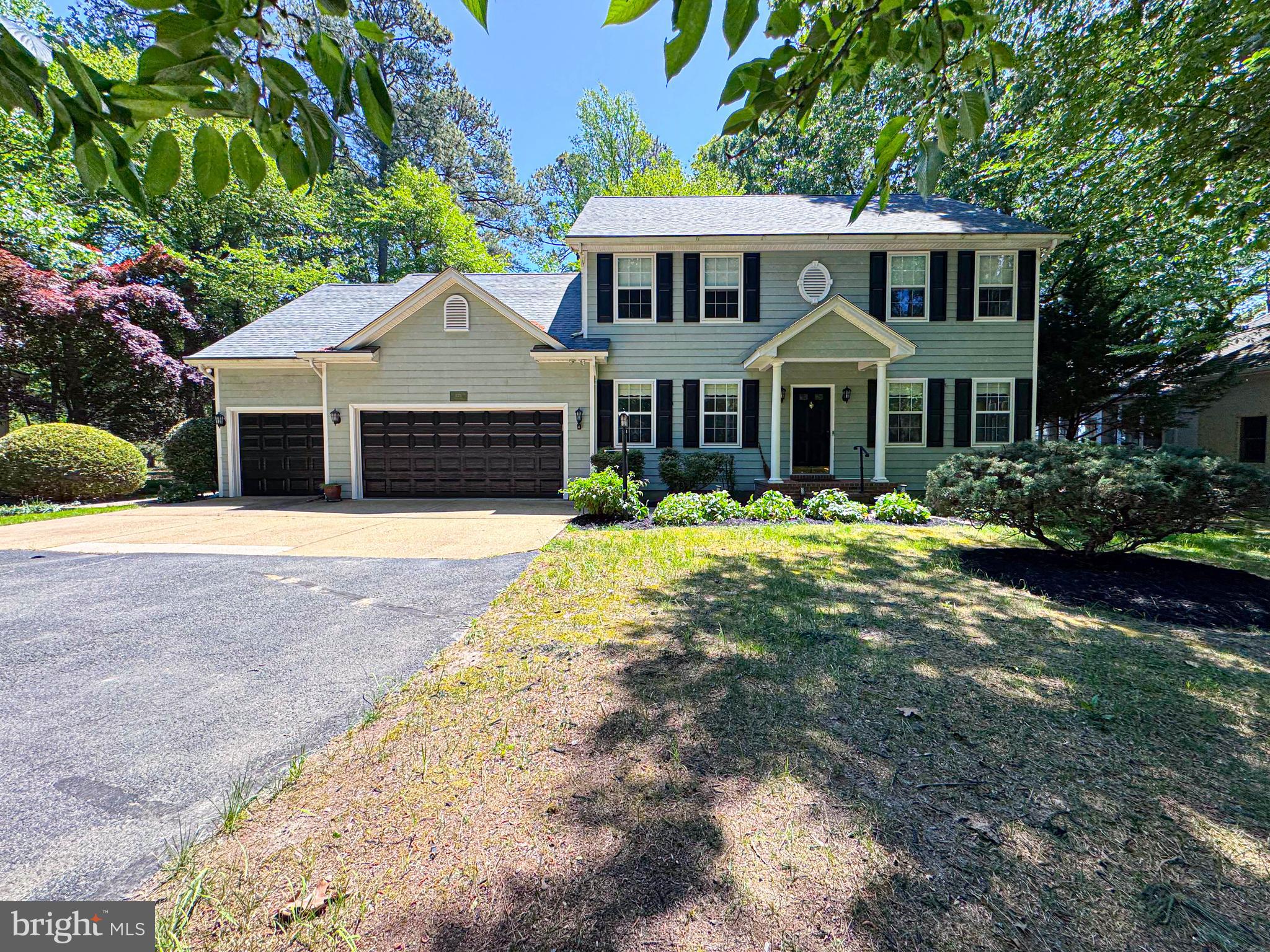 a front view of a house with a yard and trees