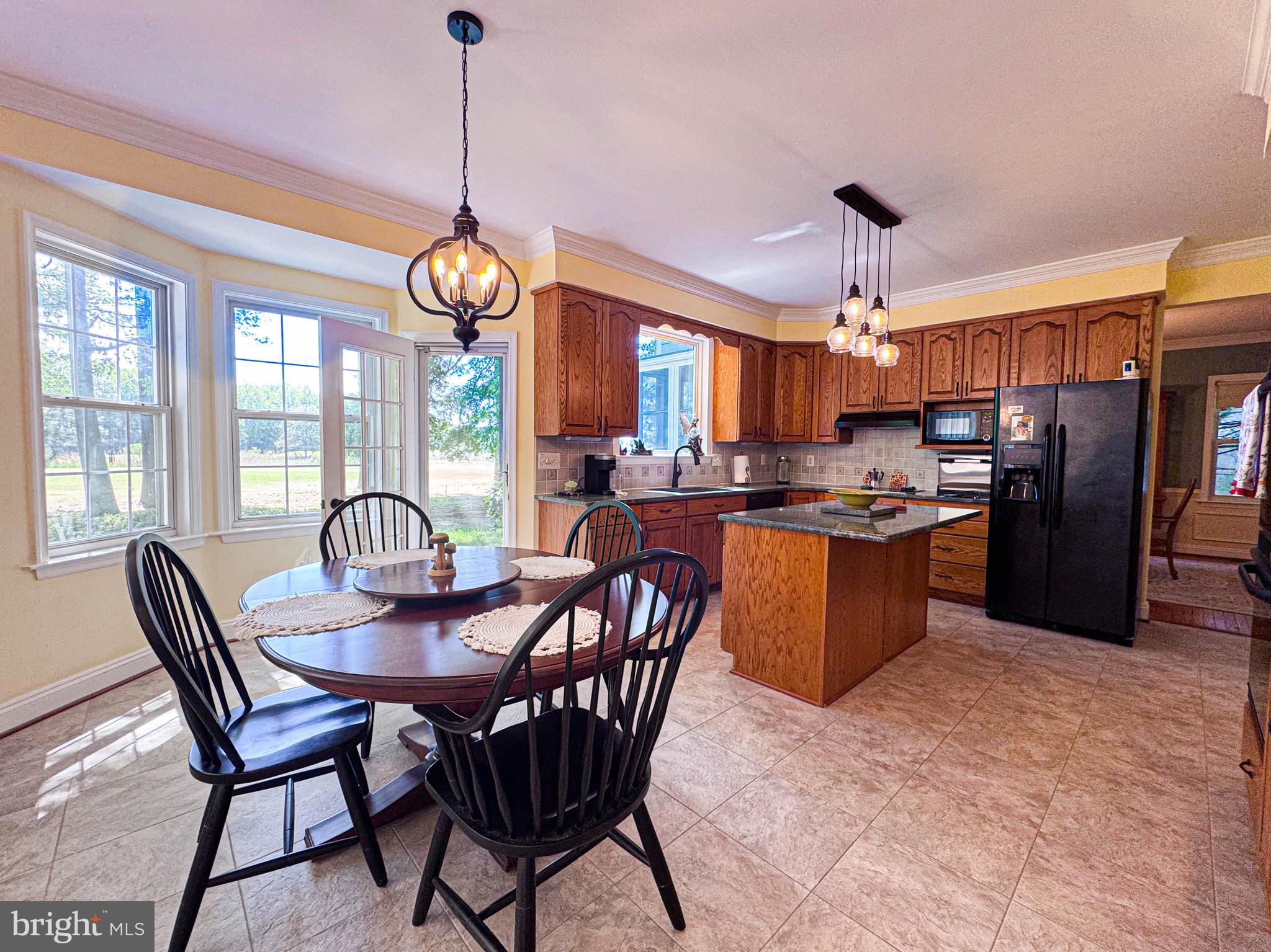 11325 Ingels Court Swan Point, MD 20645 - Photo 24 of 118 a view of a dining room with furniture large window wooden floor and chandelier