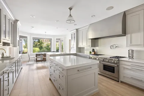 a kitchen that has a sink a stove and wooden floor