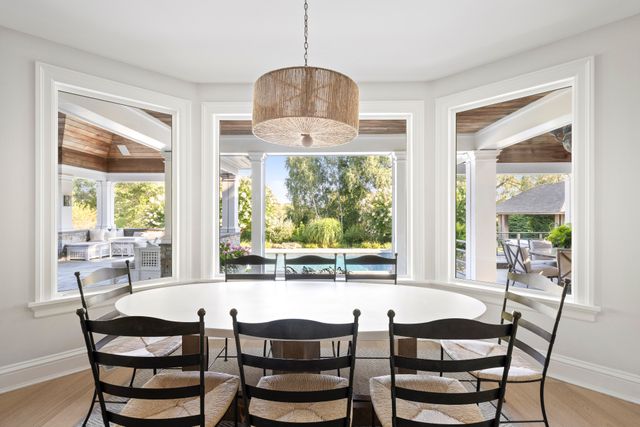 a dining room with furniture a chandelier and wooden floor