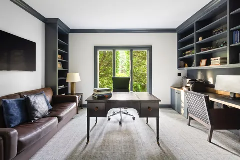 a living room with furniture a flat screen tv and a large window