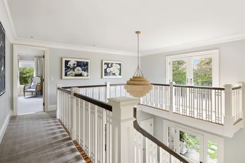 a view of staircase with railing and a chandelier