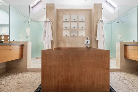 a bathroom with a tub a sink and a mirror