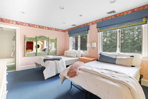 a bedroom with two beds and a large window