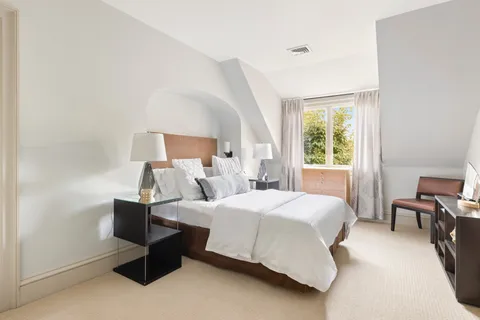 a bedroom with a bed chair and a window