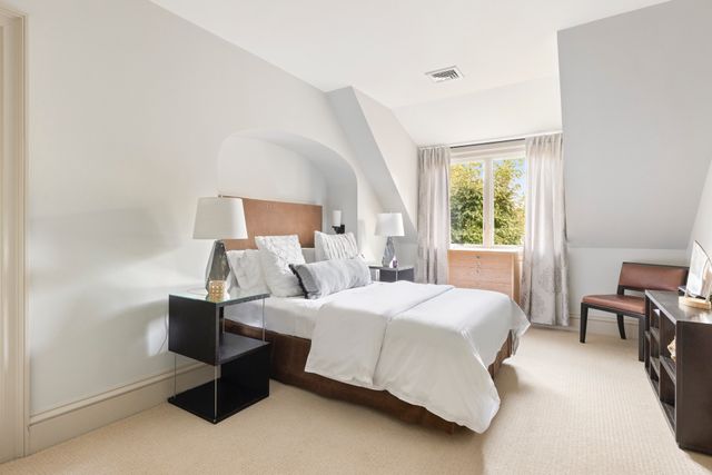 a bedroom with a bed chair and a window